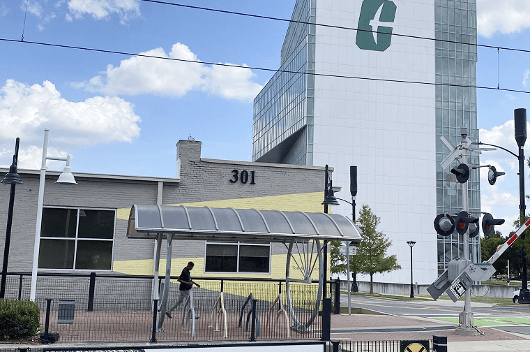 a person walks by the light rail stop, the Dubois center is seen in the distance